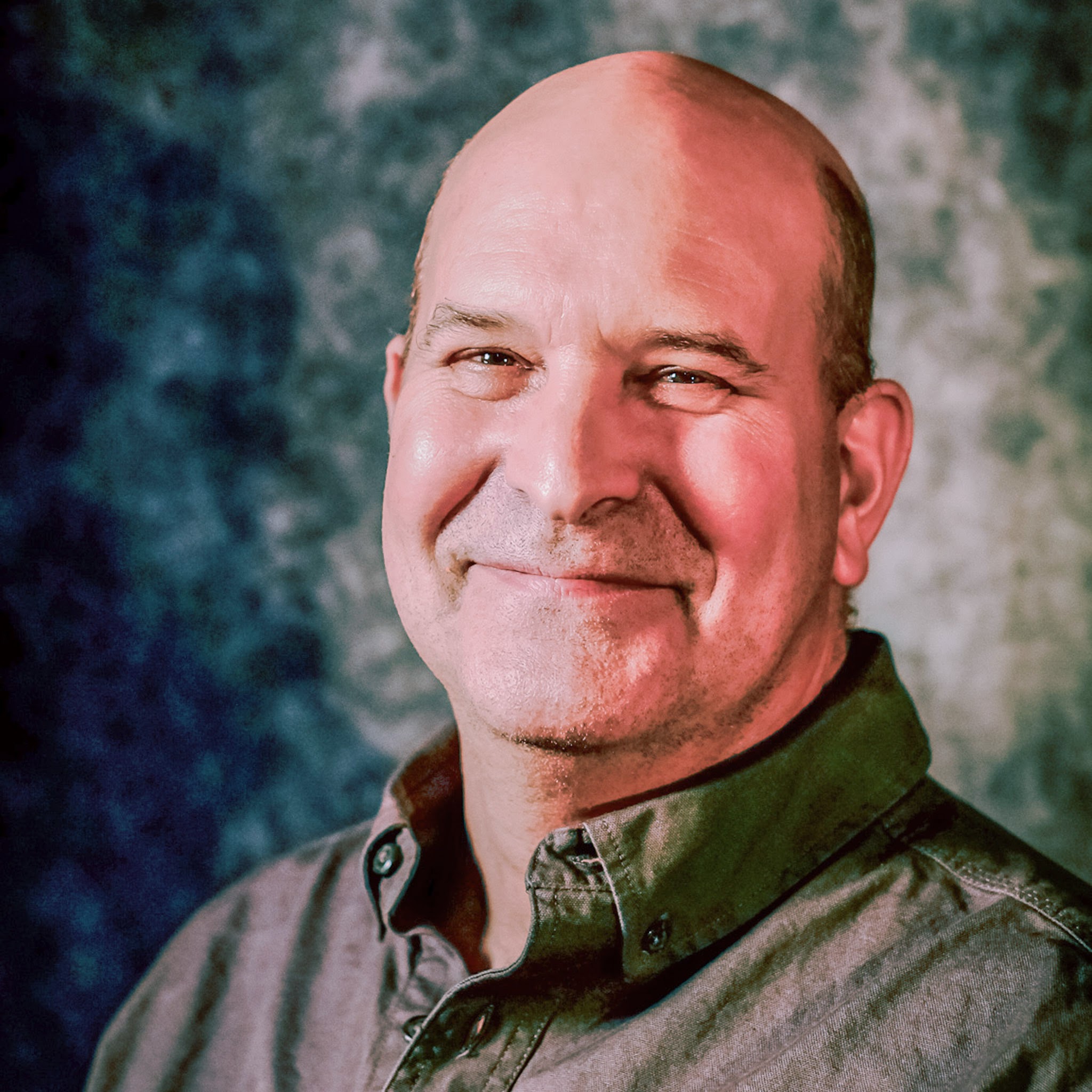 Rush Elliot Sr posed for portrait photo in gray collared shirt, bald headed