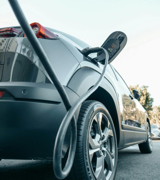 Close-up of an electric car charging at a modern charging station, showcasing clean energy technology.